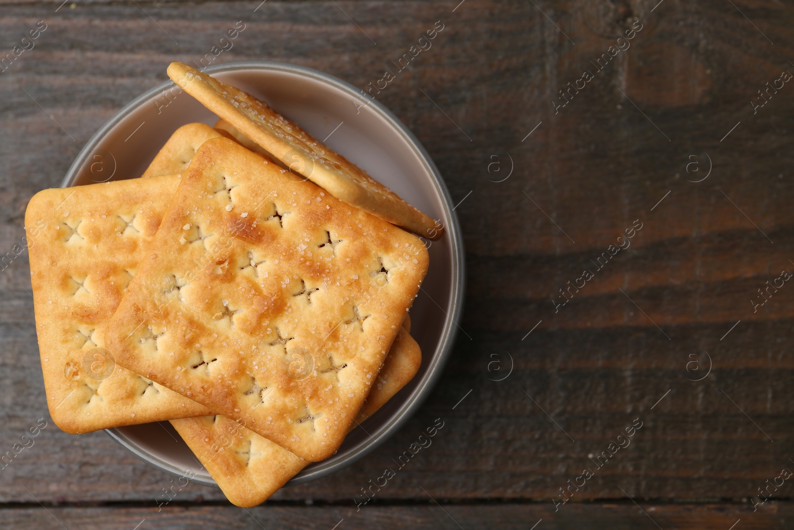 Tasty salty crackers on wooden table, top view. Space for text Photo of Tasty salty crackers on wooden table, top view. Space for text