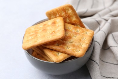 Photo of Tasty salty crackers on white table, closeup