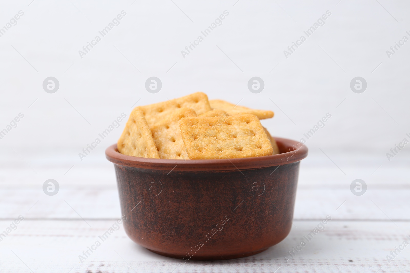 Tasty salty crackers on white wooden table, closeup Photo of Tasty salty crackers on white wooden table, closeup