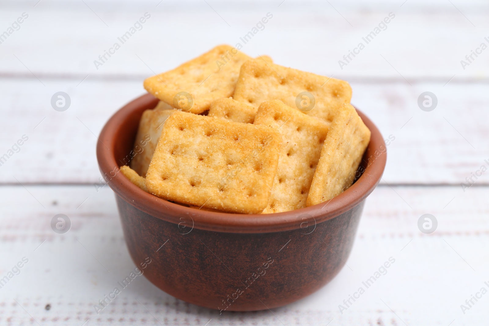 Tasty salty crackers on white wooden table, closeup Photo of Tasty salty crackers on white wooden table, closeup