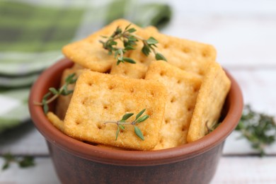Photo of Tasty salty crackers with thyme on white wooden table, closeup