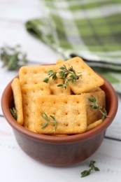 Photo of Tasty salty crackers with thyme on white wooden table, closeup