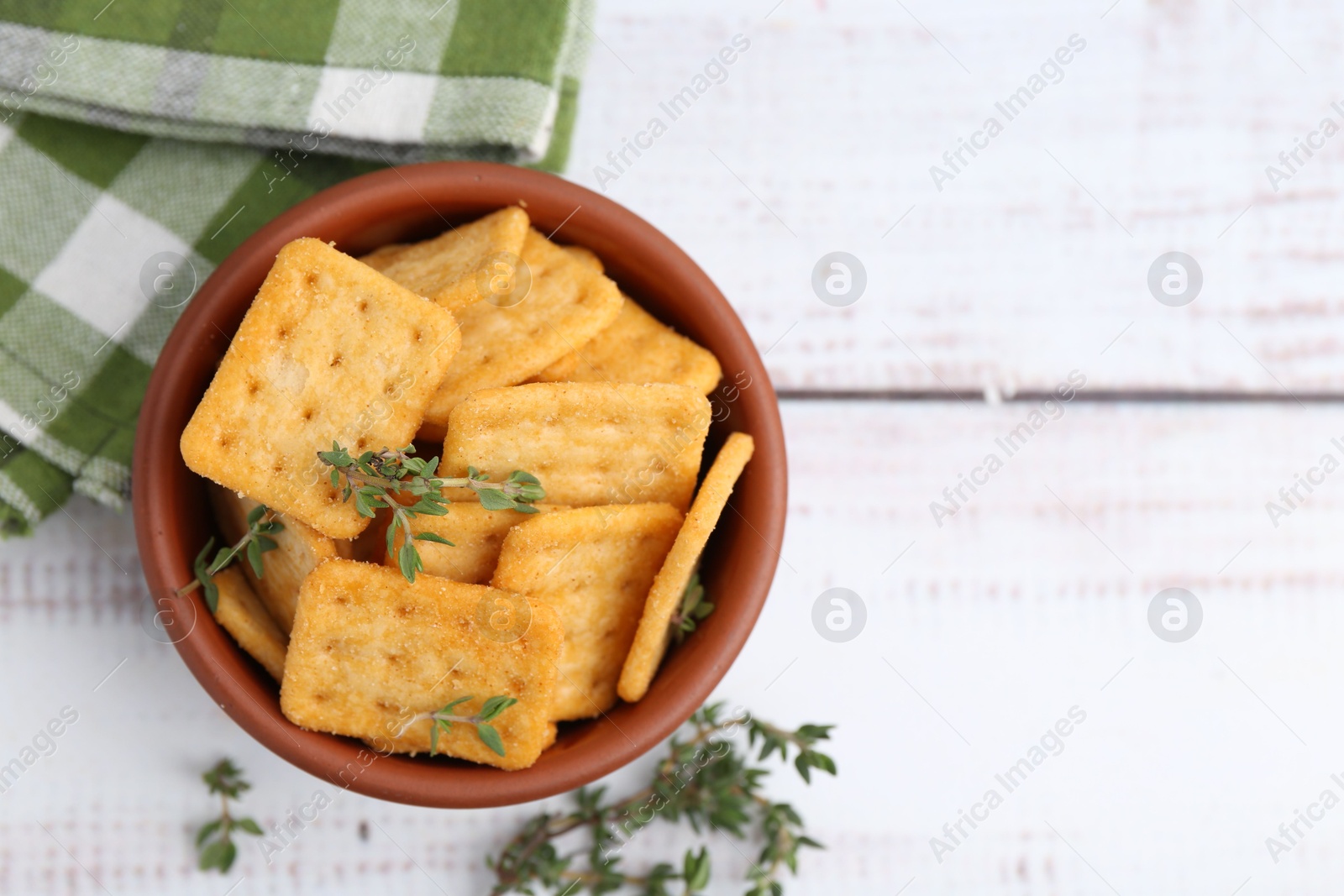 Tasty salty crackers with thyme on white wooden table, flat lay. Space for text Photo of Tasty salty crackers with thyme on white wooden table, flat lay. Space for text
