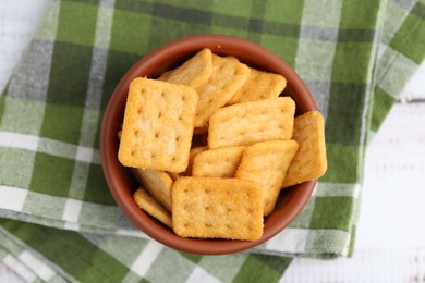 Photo of Tasty salty crackers on white wooden table, top view