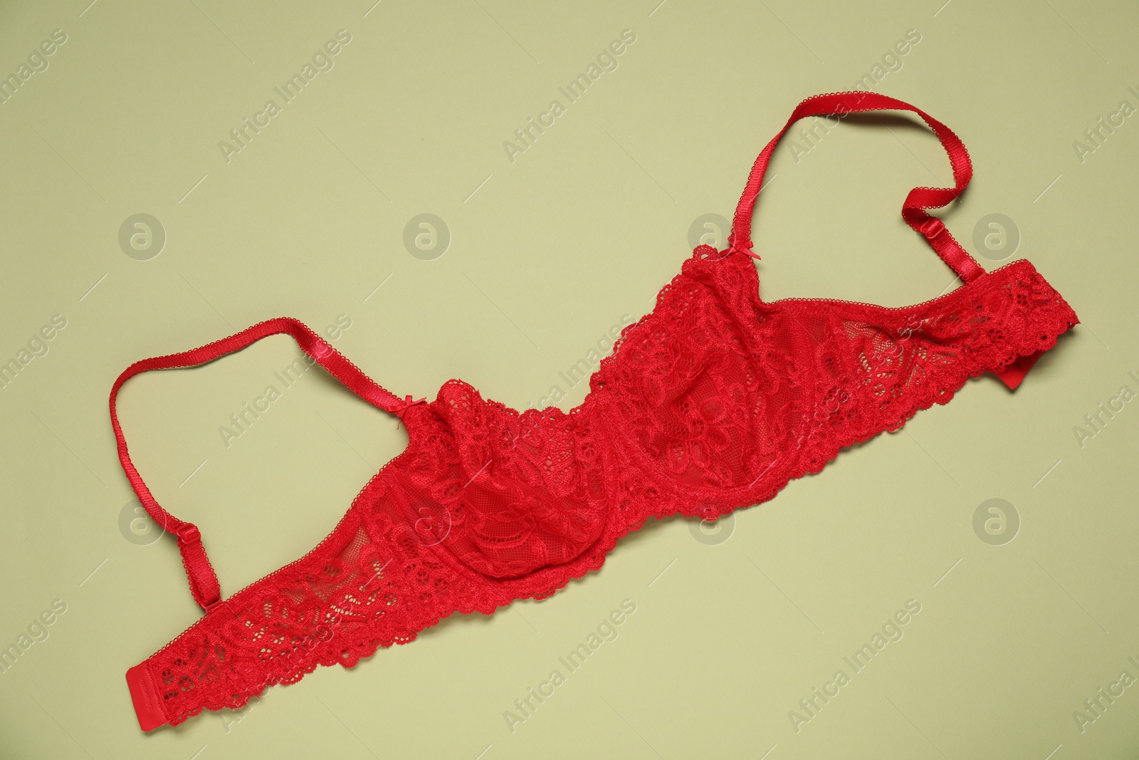 Beautiful red lace bra on light green background, top view Photo of Beautiful red lace bra on light green background, top view