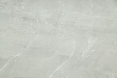 Photo of Texture of light grey marble tile as background, above view