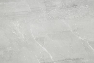 Photo of Texture of light grey marble tile as background, above view
