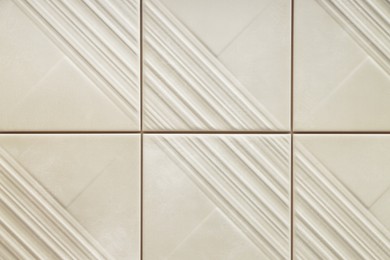 Photo of Texture of beige tiles as background, closeup