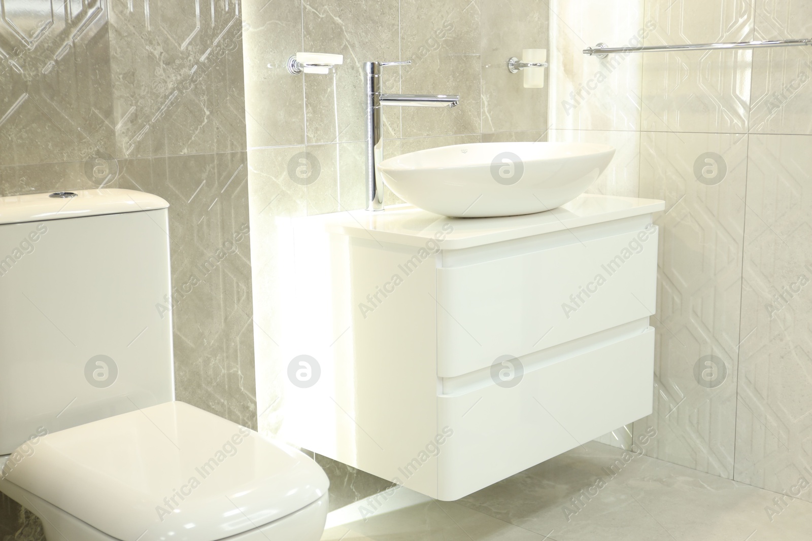 Stylish bathroom with vanity and toilet bowl near tiled wall. Interior design Photo of Stylish bathroom with vanity and toilet bowl near tiled wall. Interior design