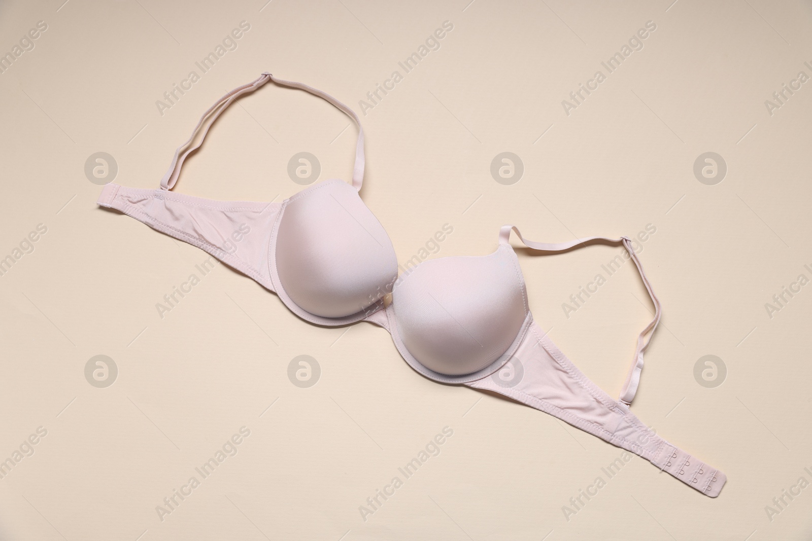 One beautiful bra on beige background, top view Photo of One beautiful bra on beige background, top view