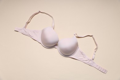 Photo of One beautiful bra on beige background, top view