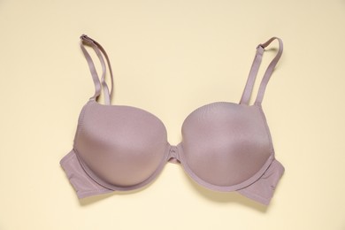 Photo of One beautiful bra on beige background, top view