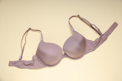 Photo of One beautiful bra on beige background, top view