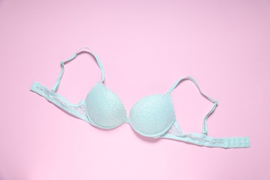 Photo of One lace bra on pink background, top view