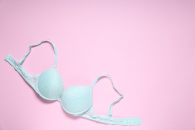 Photo of One lace bra on pink background, top view. Space for text