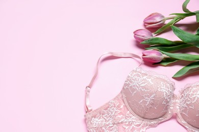 Photo of Lace bra and tulip flowers on pink background, flat lay. Space for text