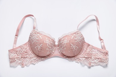 Photo of One pink lace bra on white background, top view