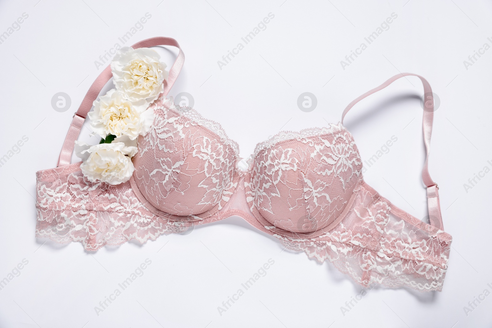 Pink lace bra and eustoma flowers on white background, top view Photo of Pink lace bra and eustoma flowers on white background, top view