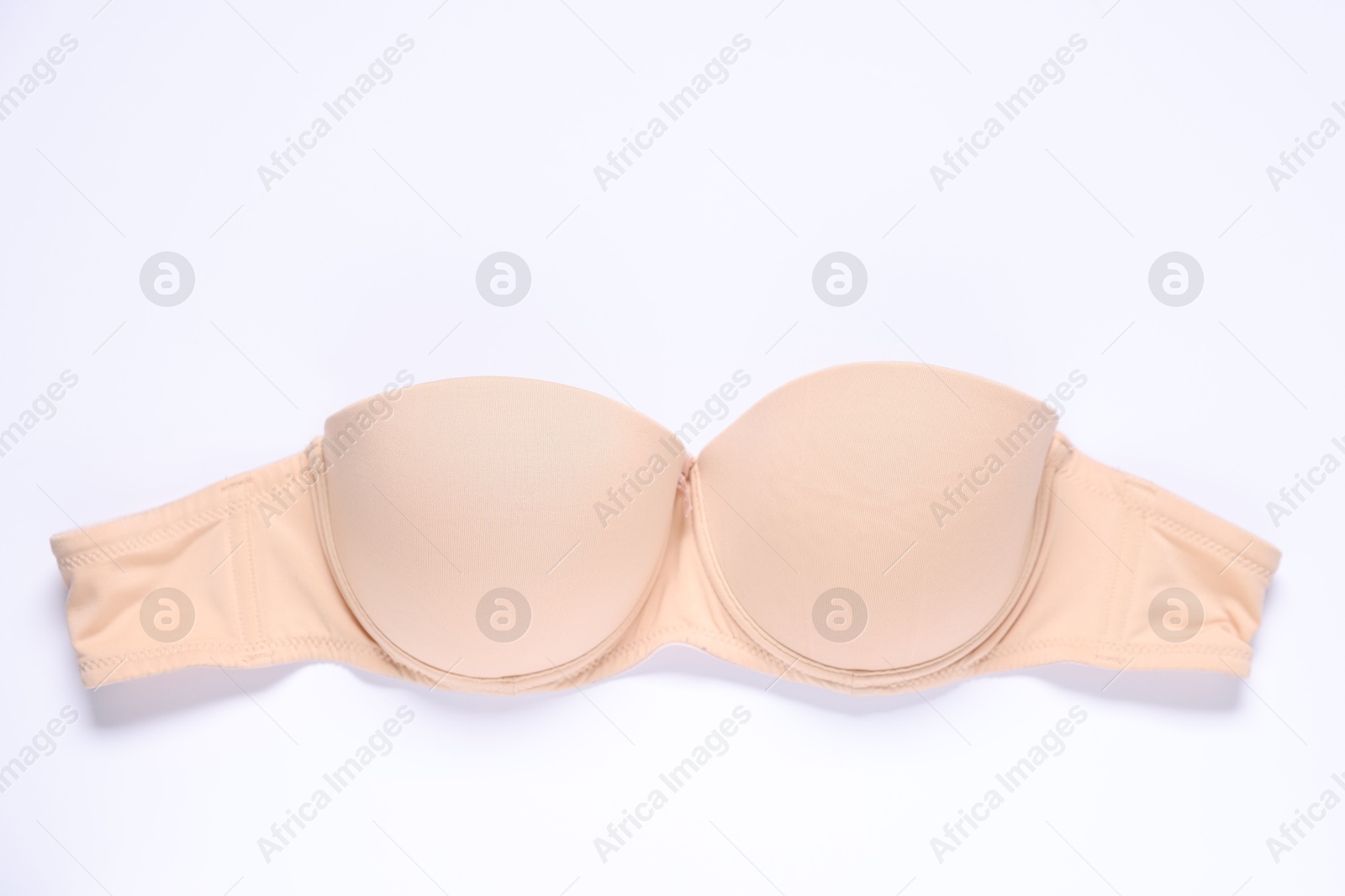 One beige bra on white background, top view Photo of One beige bra on white background, top view