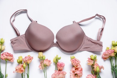 Photo of Beautiful bra and eustoma flowers on white background, flat lay