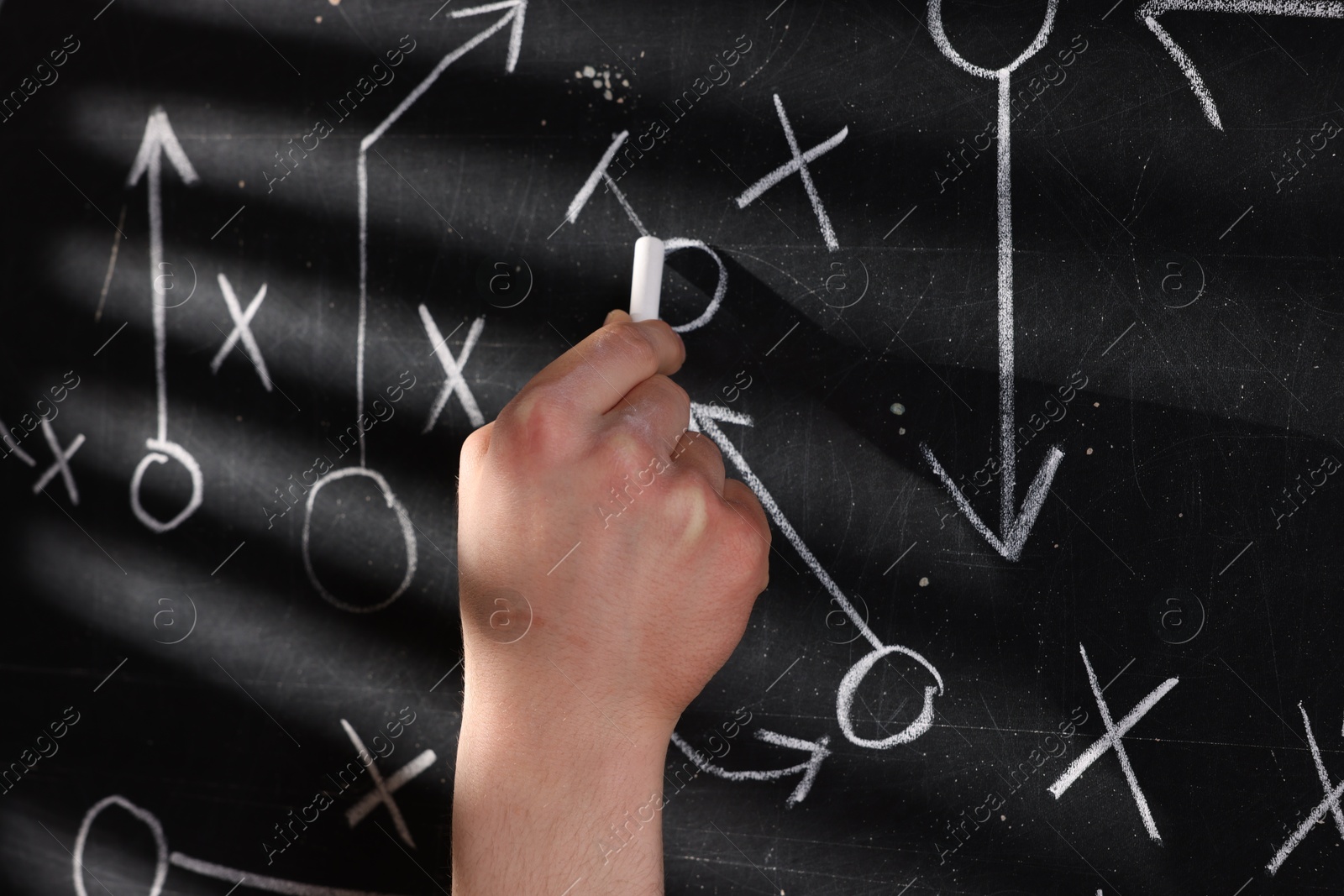 Man drawing American football game scheme on chalkboard, closeup Photo of Man drawing American football game scheme on chalkboard, closeup