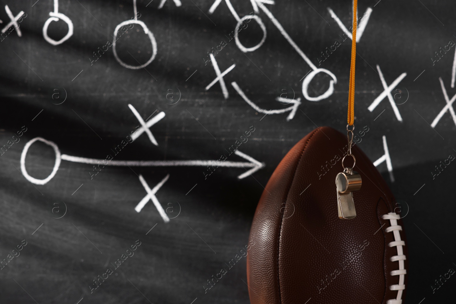 American football ball near chalkboard with scheme of game, closeup Photo of American football ball near chalkboard with scheme of game, closeup