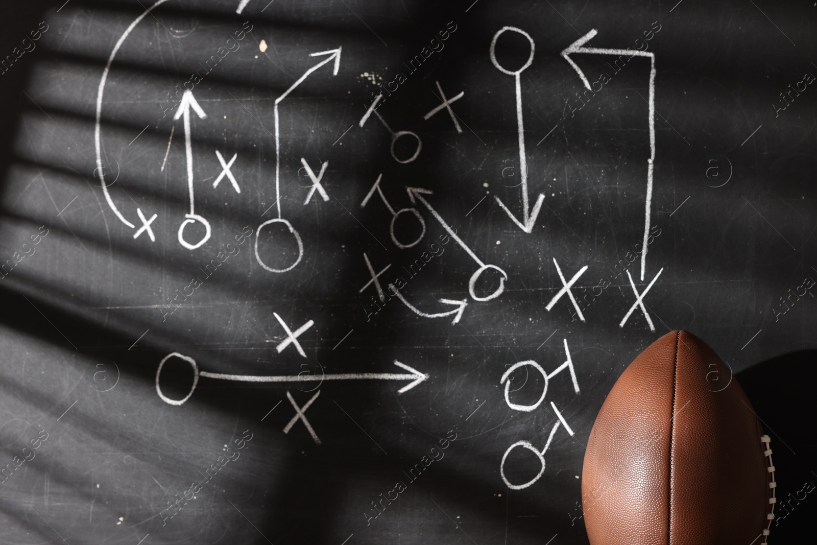 American football ball near chalkboard with scheme of game Photo of American football ball near chalkboard with scheme of game