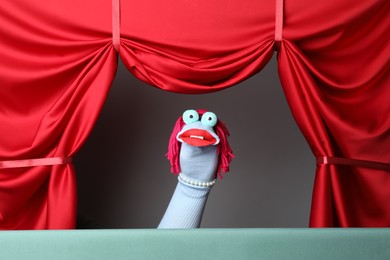 Photo of Creative puppet show on stage with red curtains