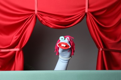 Photo of Creative puppet show on stage with red curtains