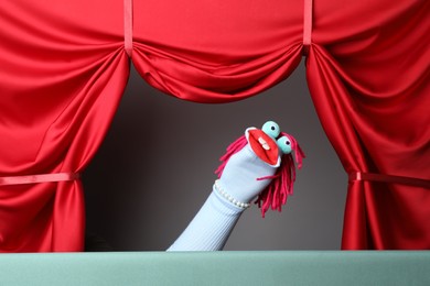 Photo of Creative puppet show on stage with red curtains