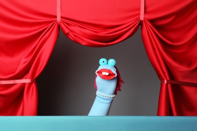 Photo of Creative puppet show on stage with red curtains