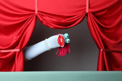 Photo of Creative puppet show on stage with red curtains