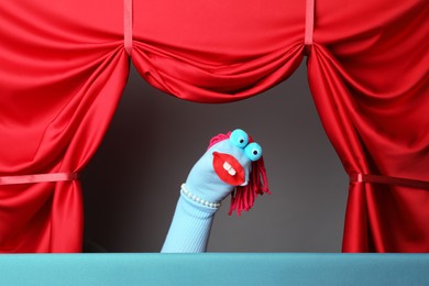 Photo of Creative puppet show on stage with red curtains