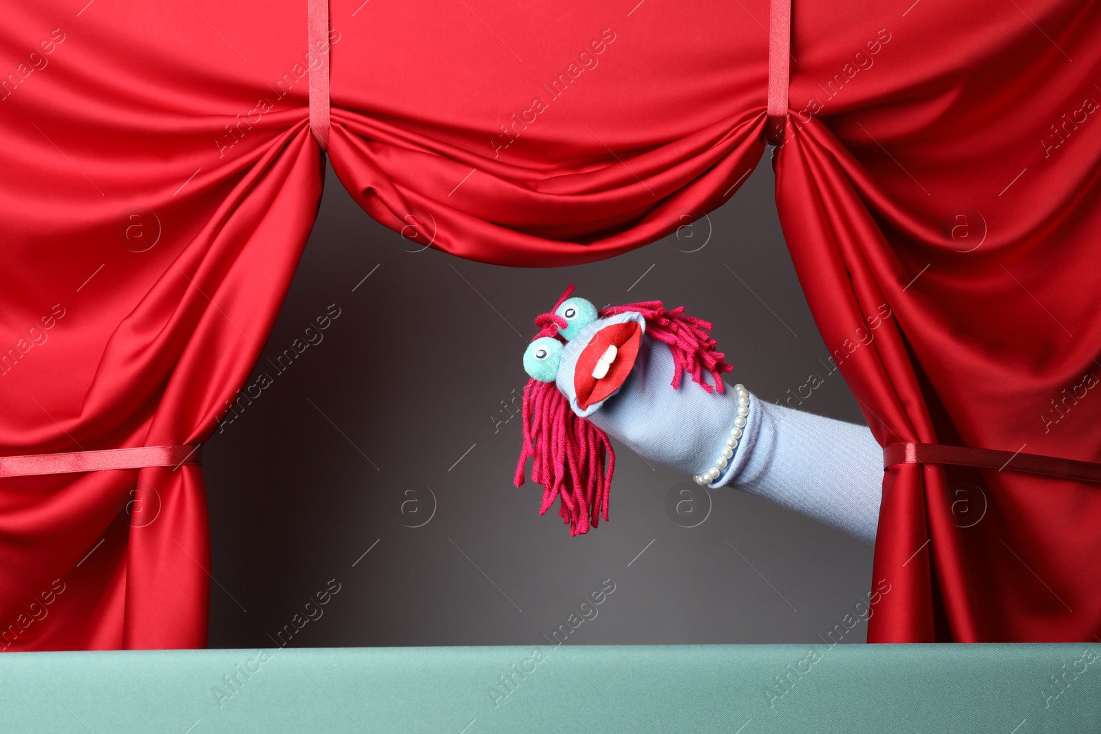 Creative puppet show on stage with red curtains Photo of Creative puppet show on stage with red curtains