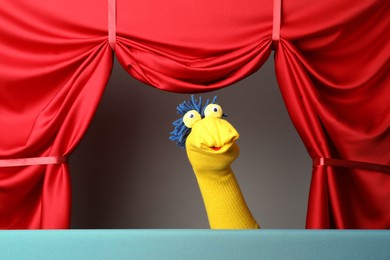 Photo of Creative puppet show on stage with red curtains