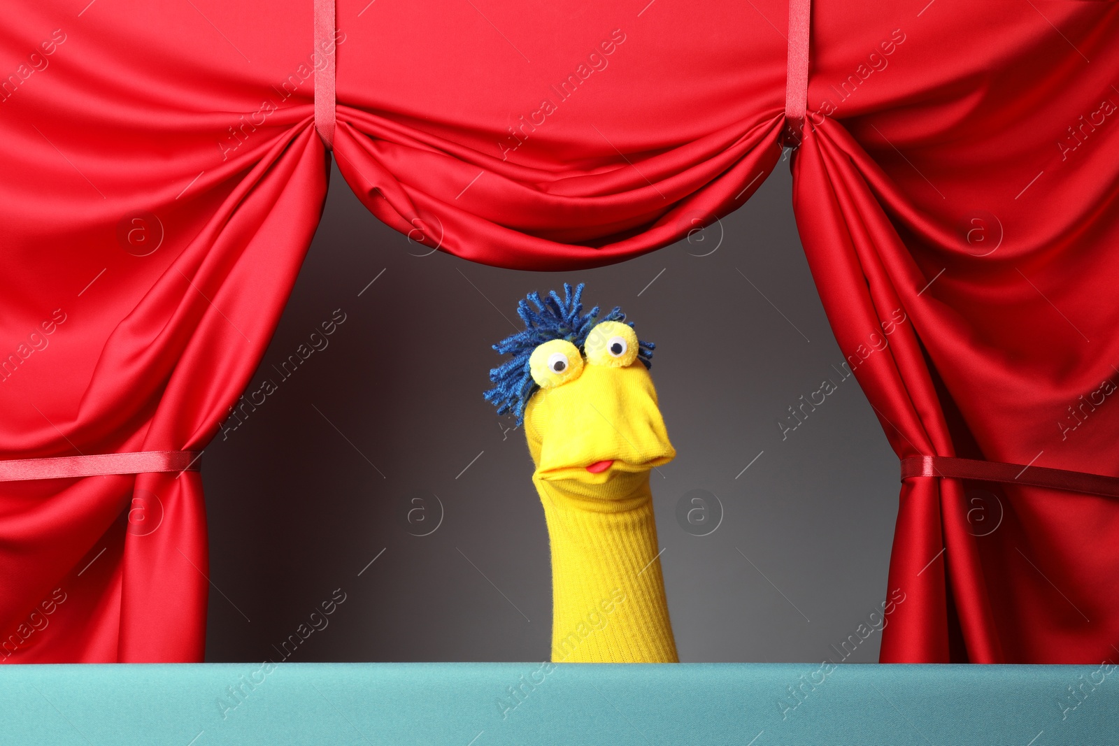 Creative puppet show on stage with red curtains Photo of Creative puppet show on stage with red curtains