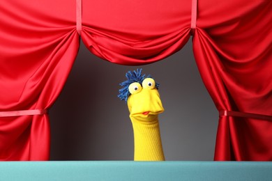 Photo of Creative puppet show on stage with red curtains