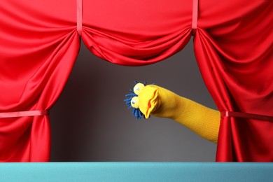 Photo of Creative puppet show on stage with red curtains