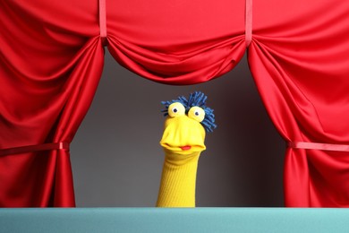 Photo of Creative puppet show on stage with red curtains