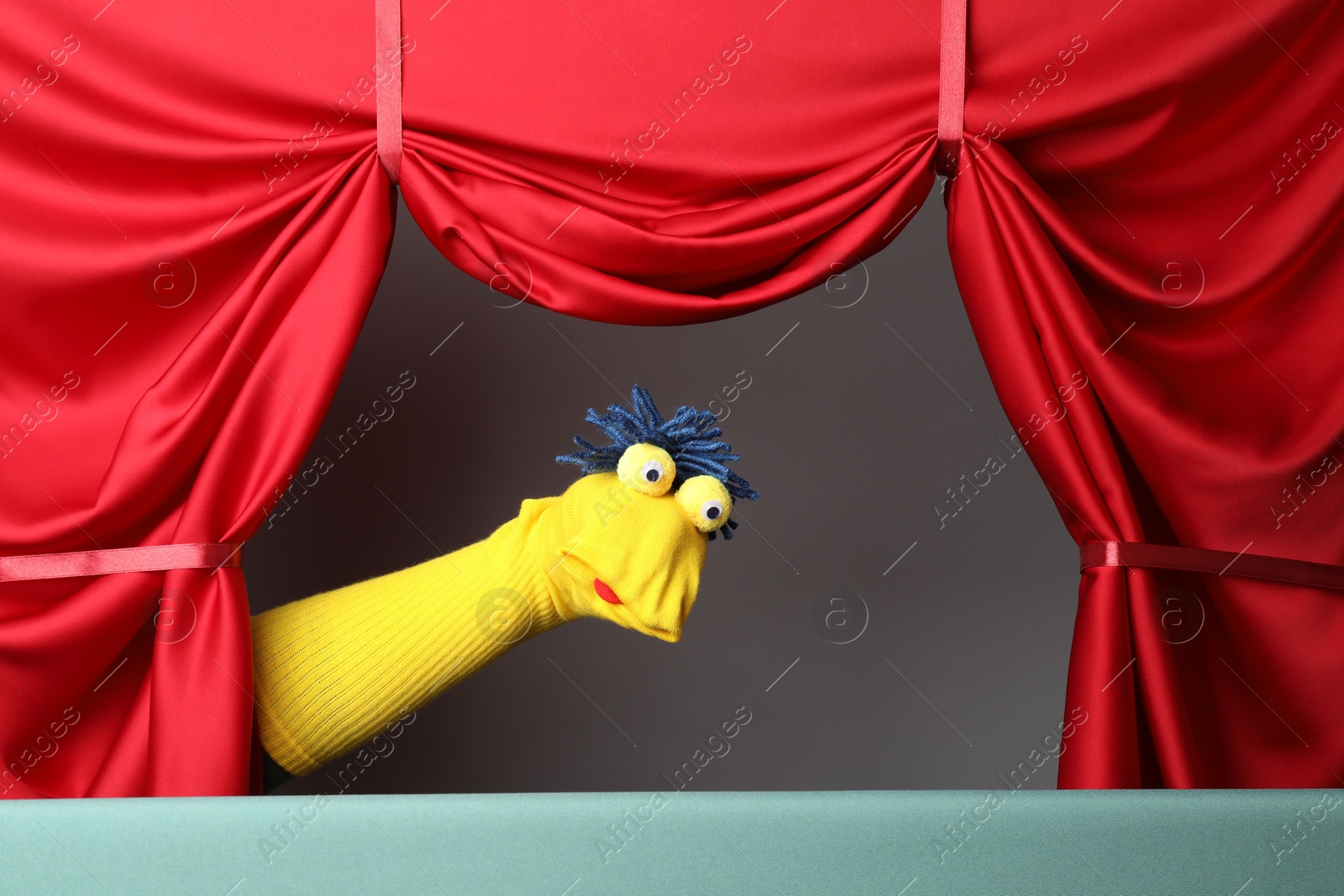Creative puppet show on stage with red curtains Photo of Creative puppet show on stage with red curtains
