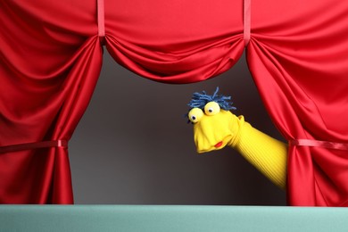 Photo of Creative puppet show on stage with red curtains