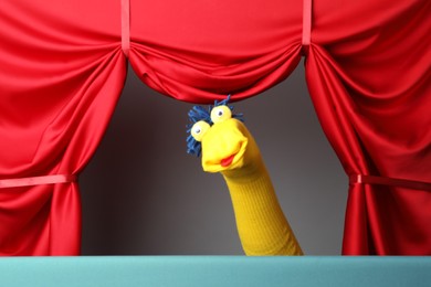 Photo of Creative puppet show on stage with red curtains