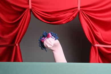 Photo of Creative puppet show on stage with red curtains
