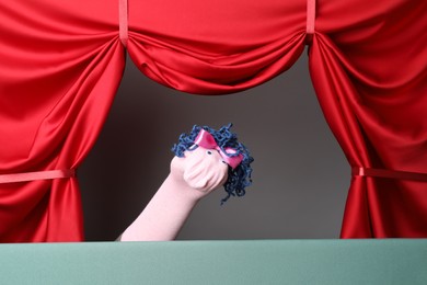 Photo of Creative puppet show on stage with red curtains