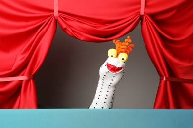 Photo of Creative puppet show on stage with red curtains