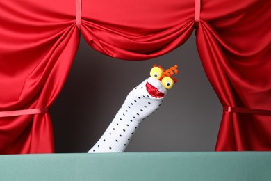 Photo of Creative puppet show on stage with red curtains