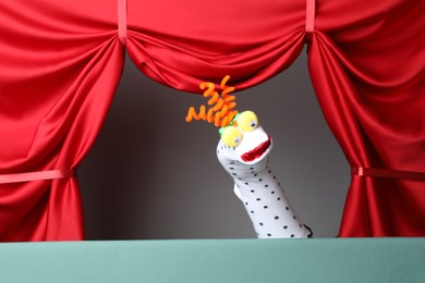 Photo of Creative puppet show on stage with red curtains