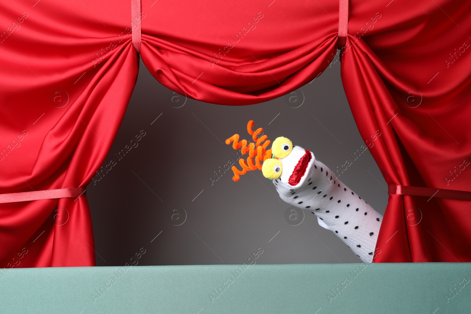Creative puppet show on stage with red curtains Photo of Creative puppet show on stage with red curtains