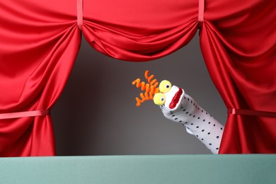 Photo of Creative puppet show on stage with red curtains