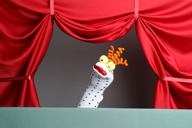 Photo of Creative puppet show on stage with red curtains